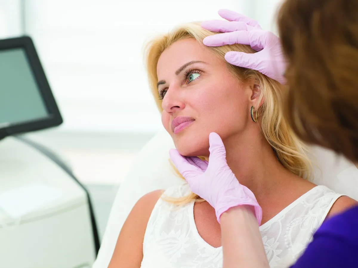 A dermatologist examining a patient’s skin during a consultation