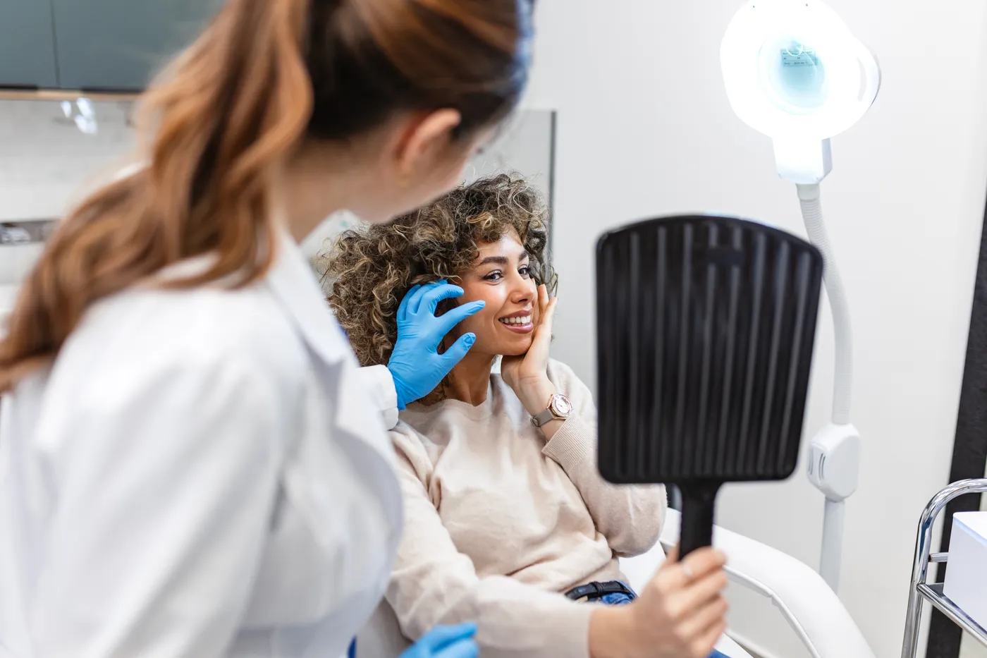 A dermatologist examining a patient’s skin during a consultation