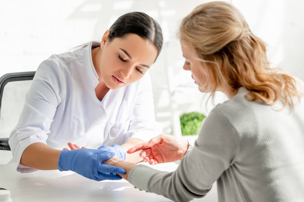 doctor checking patient with an eczema