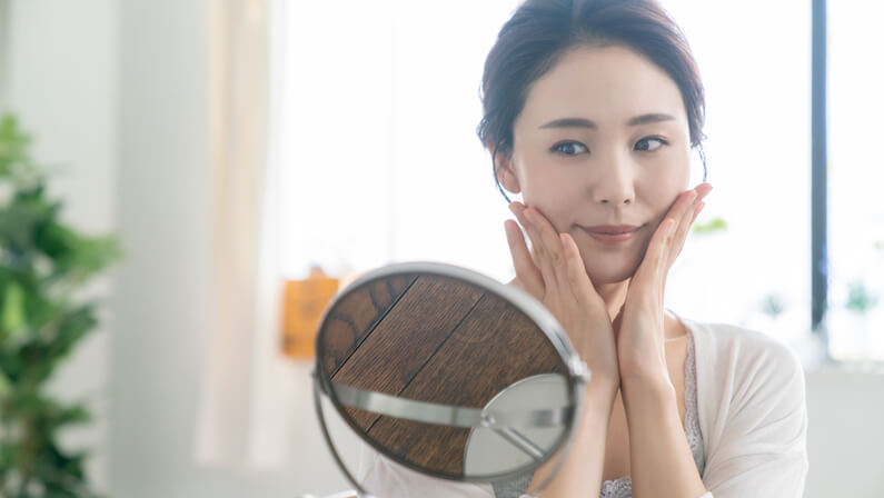 young women with fair skin facing the mirror