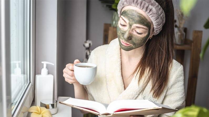 beautiful lady applying green tea on her face