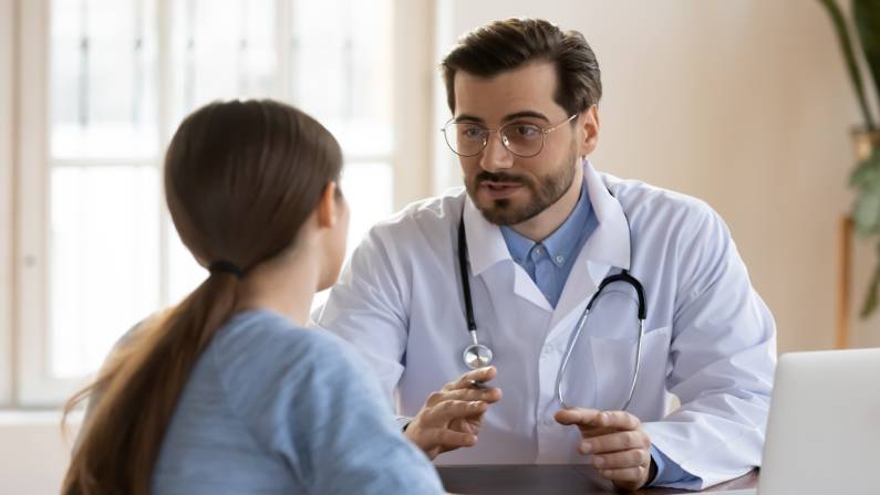 male doctor in white medical uniform talk discuss results or symptoms with female patient